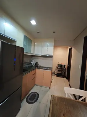 a kitchen with white cabinets and a table in it at RL airport haven in Manila
