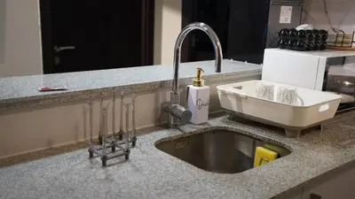 a kitchen counter with a sink and a sink at Luxury 2BR in Uptown Parksuites BGC Balcony & Prime location in Manila
