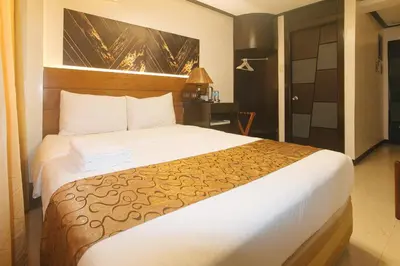 a bedroom with a large bed in a hotel room at The Shilla Philia Hotel by RedDoorz in Manila