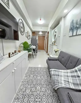 a living room with a couch and a kitchen at New Crib at Shore 3 in Manila