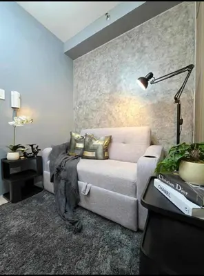 a living room with a couch and a lamp at Sakura Suite at Shore 2 in Manila