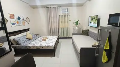 a living room with a bed and a couch in it at Manila Airport Hub near NAIA T3 -101 Newport Boulevard in Manila