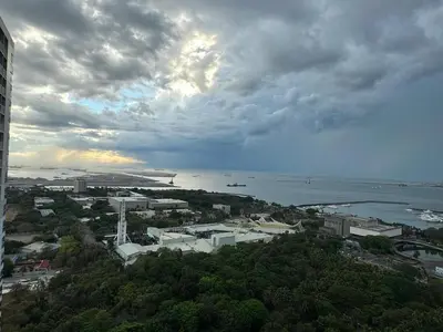 a view of a city and the ocean under a cloudy sky at Sunset heights SMDC Breeze Residences Pasay in Manila