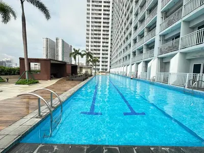 a large swimming pool in the middle of a building at Sunset heights SMDC Breeze Residences Pasay in Manila