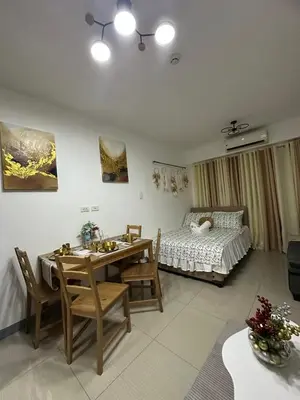 a living room with a dining table and a bed at Pyeong on Suite SMDC Shore Residences Mall of Asia Pasay in Manila