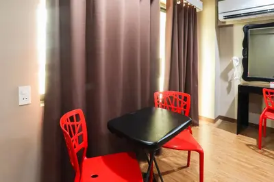 a room with a table and two chairs and a television at Hotel Sogo Baclaran in Manila