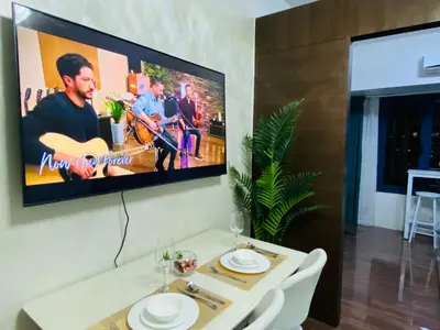 a tv hanging on a wall in a living room at City View Skyline - Air Residence in Manila