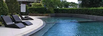 a swimming pool with two chairs sitting next to it at Avant BGC 2 Bedroom in Manila