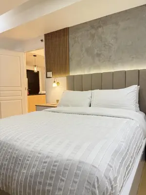 a bedroom with a large bed with a white comforter at Avant BGC 2 Bedroom in Manila