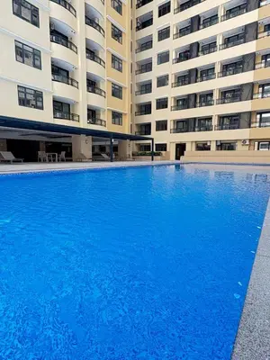 a large blue swimming pool in front of a building at Sy bay Suites TwinBed near Okada MOA PITX NAIA cod MSV1502H in Manila