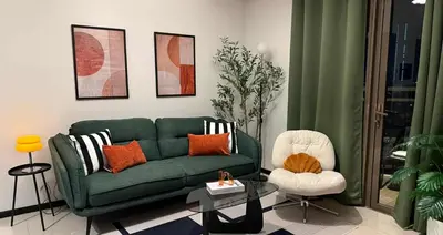 a living room with a green couch and a chair at Casa Forma in Manila
