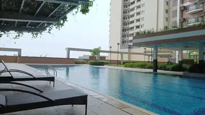 a large swimming pool in a building with benches at Casa Forma in Manila