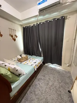 a bedroom with a bed and a window with curtains at Shell and Shorline Bliss Manila Staycation in Manila