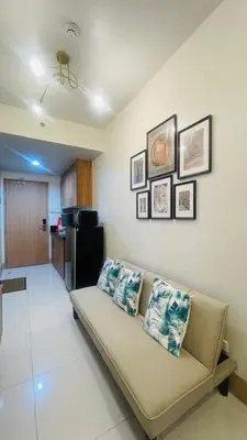 a living room with a couch and a kitchen at Lana Haven in Manila
