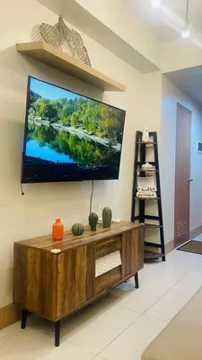 a living room with a large flat screen tv on the wall at Lana Haven in Manila