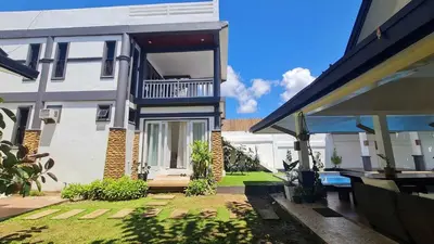 a white house with a yard with a patio at OYO 1175 Casa Ana in Manila