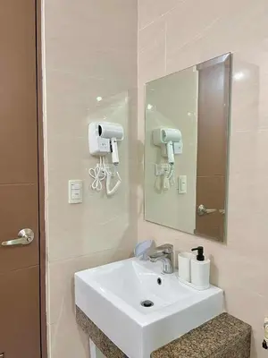 a bathroom with a white sink and a mirror at Big Studio Condo Across Manila Airport NAIA T3 WITH WIFI in Manila