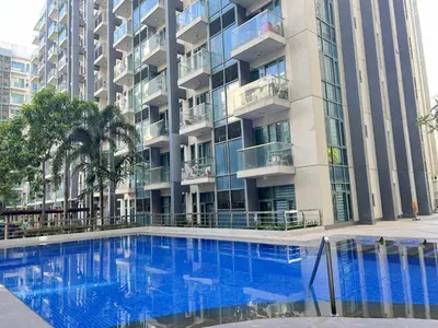 a large apartment building with a large blue swimming pool at Big Studio Condo Across Manila Airport NAIA T3 WITH WIFI in Manila