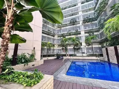 a building with a swimming pool in front of a building at Condo Unit Near NAIA T3 in Manila