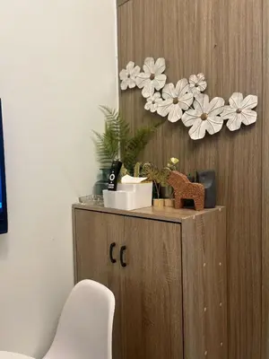 a wooden cabinet with flowers on the wall at Shore 2 Residences - The Grand Haven in Manila