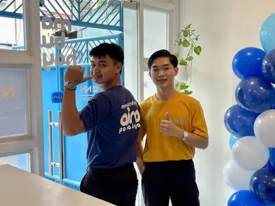 two men standing next to each other in front of balloons at airobedz ZOBEL ROXAS- A Value Hotel in Manila