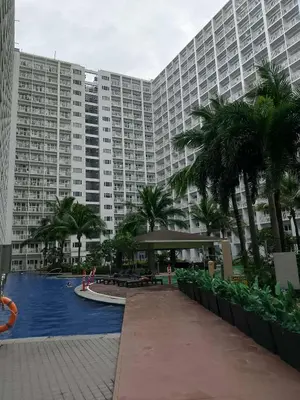 a large building with a swimming pool in front of it at Condo MOA Complex Pasay - Shore 1 Tower D Residence - Home away from Home in Manila