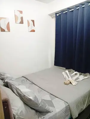 a bed with a pair of white shoes on it at Condo MOA Complex Pasay - Shore 1 Tower D Residence - Home away from Home in Manila