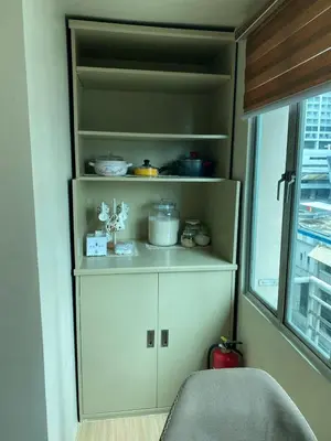 a kitchen with white cabinets and a window at Whereabouts Midway Condotel in Manila