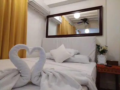 a bed with two swans made out of towels at Makati Riverside Inn in Manila