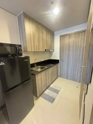 a kitchen with a black refrigerator and a sink at Canadian Suite at Coast Residences Penthouse in Manila