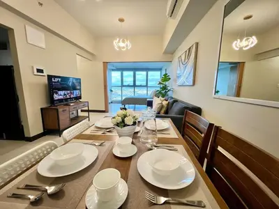 a dining room with a table with plates and silverware at Upscale 2BR in Uptown Parksuites with Free Parking in Manila