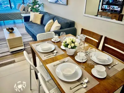 a dining room table with white plates and chairs at Upscale 2BR in Uptown Parksuites with Free Parking in Manila