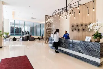 a man and a woman standing at a counter in a lobby at Upscale 2BR in Uptown Parksuites with Free Parking in Manila