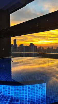 a view of a city skyline at sunset from a building at Christine Suites PH at The Gramercy Residences Makati in Manila