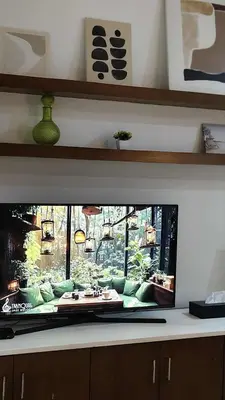 a flat screen tv sitting on a counter in a living room at Christine Suites PH at The Gramercy Residences Makati in Manila