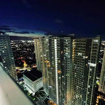 a view of a city at night with tall buildings at Masie Beach Staycation in Manila