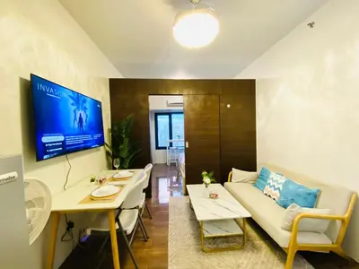 a living room with a couch and a table at Tropical Chic Escape With City lights View- Modern Scandi in Manila