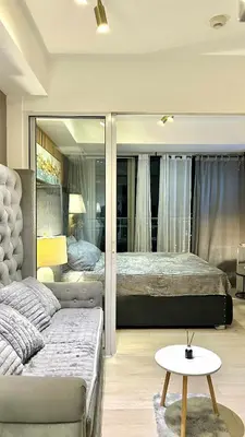 a bedroom with two beds and a table in front of a mirror at Azure Skyline Pad in Manila