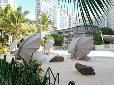 a group of umbrellas on a beach with buildings at Azure Skyline Pad in Manila