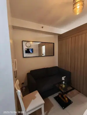 a living room with a black couch and a table at Shore Residences MOA in Manila