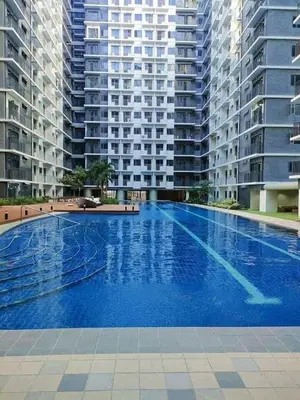 a large swimming pool in front of tall buildings at Shore Residences MOA in Manila