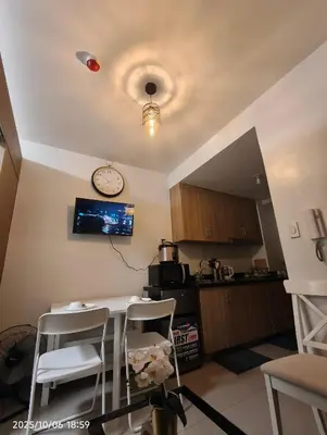 a kitchen with a table and a clock on the ceiling at Shore Residences MOA in Manila
