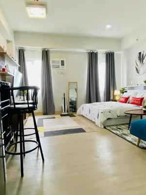 a bedroom with a bed and a table and a chair at Condo Stay Near SM City Santa Rosa Mall in Ibaba