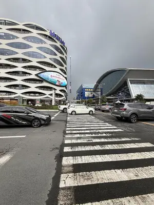 a parking lot with cars parked in front of a building at Monarch Parksuites 1BR with balcony in Manila