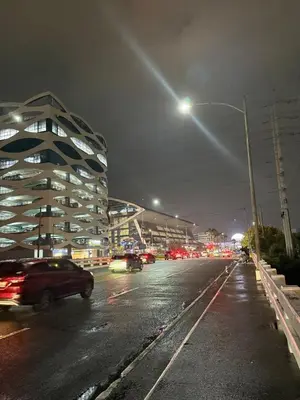a city street at night with cars on the road at Monarch Parksuites 1BR with balcony in Manila