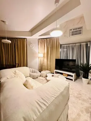 a bedroom with a large bed and a flat screen tv at The Dreamy Cloud by Kozy Mood in Manila
