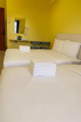 two beds in a room with yellow walls at T1 Stay Manila-Near NAIA Manila Airport and PITX in Manila