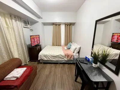a living room with two beds and a couch at 1BR Minimalist Family Staycation in Manila