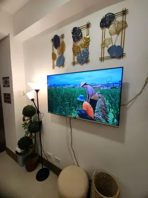 a flat screen tv hanging on a wall at Japan Vibe Shaw MRT Train EDSA 1BR with Veranda Netflix Internet Pool View in Manila