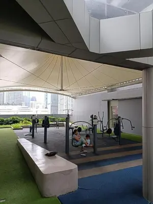 a gym with a woman sitting on a bench at Japan Vibe Shaw MRT Train EDSA 1BR with Veranda Netflix Internet Pool View in Manila